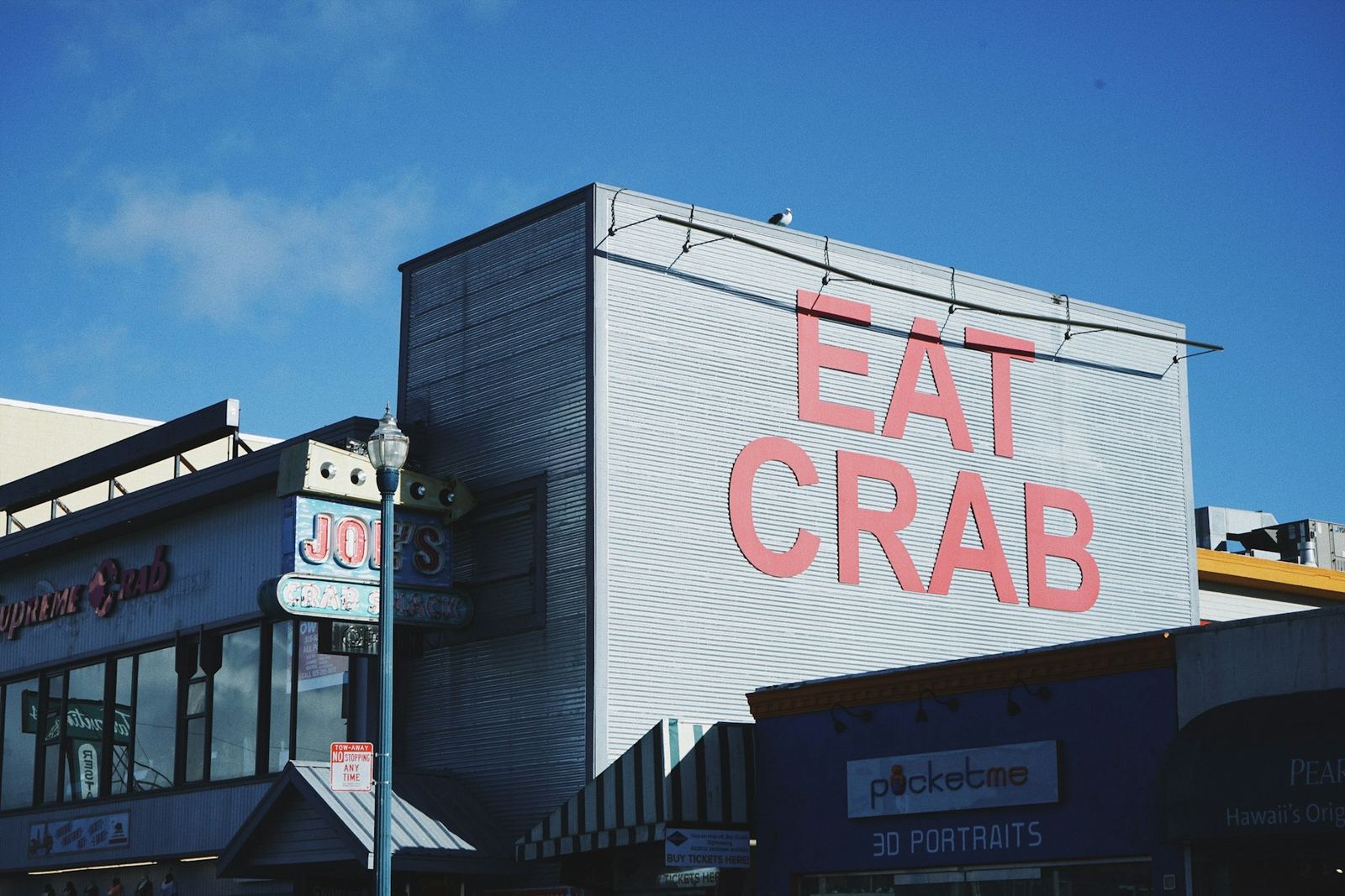 A building with a huge red EAT CRAB sign against a blue sky